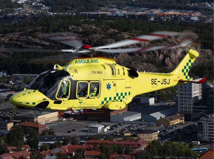A yellow helicopter with a red cross on it is flying over a city. AI generated content