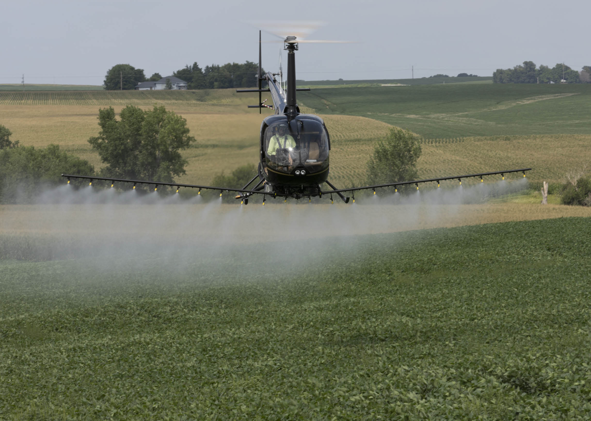 A helicopter is spraying water on a field. AI generated content