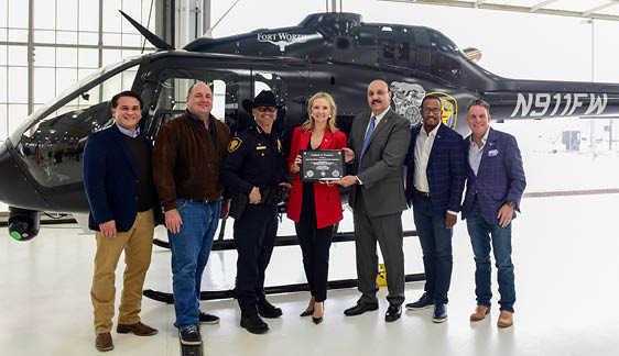 A group of people pose for a photo in front of a helicopter. AI generated content