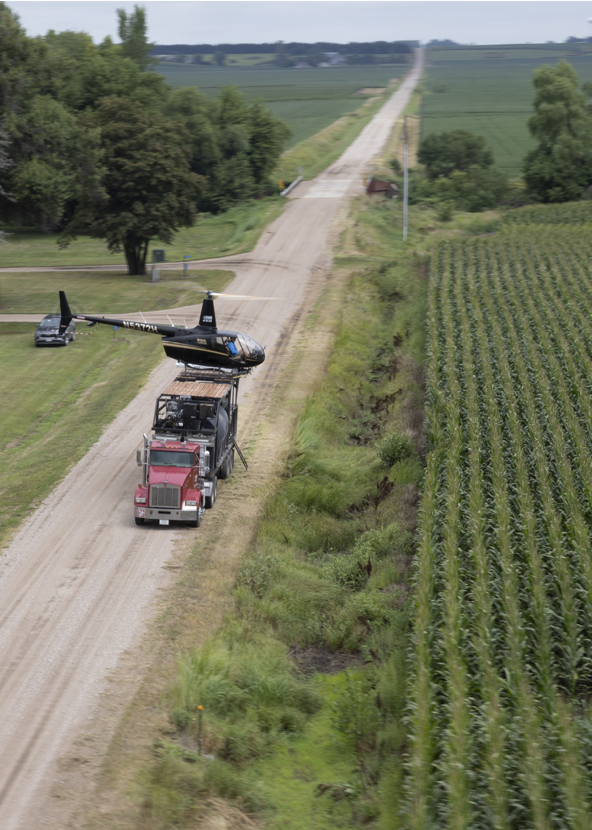 A helicopter is being loaded onto a truck in a rural setting. AI generated content