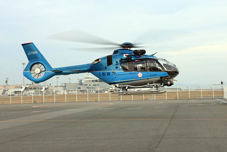 A blue helicopter with a large propeller is on the ground. AI generated content