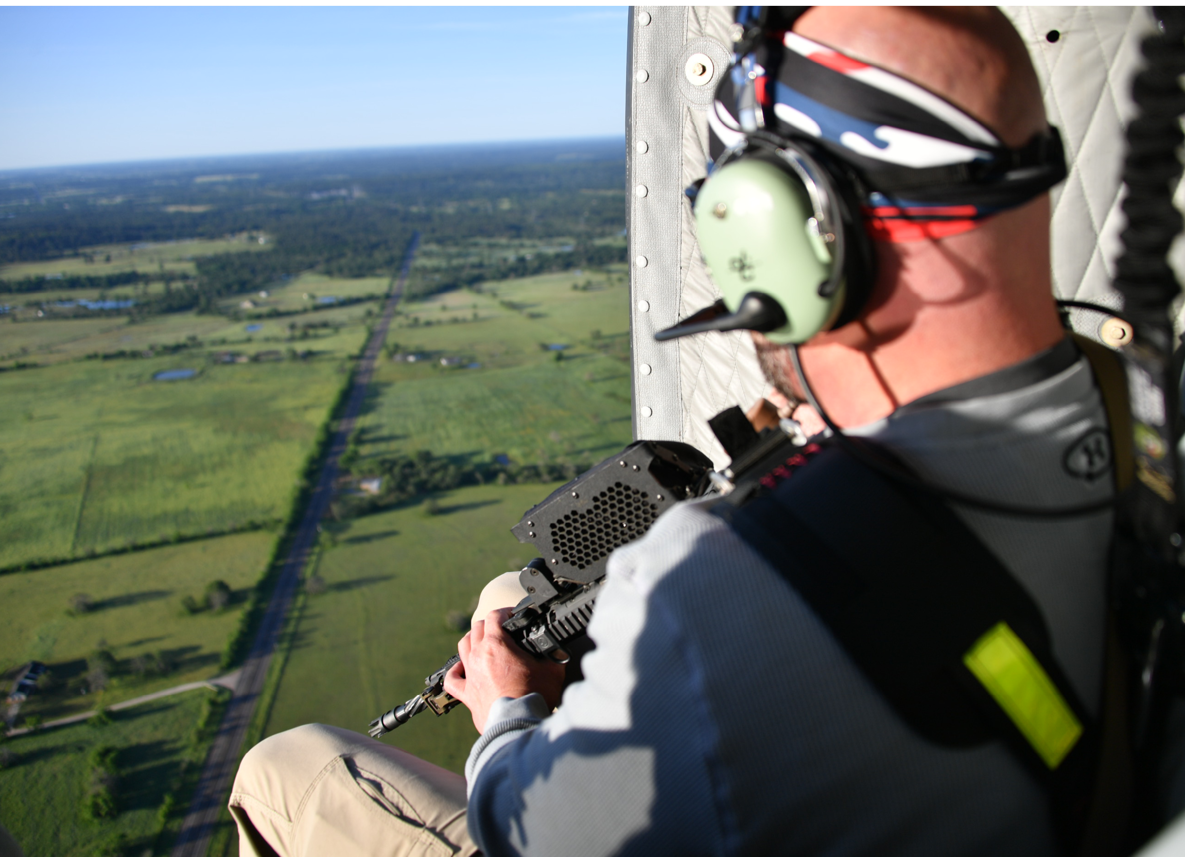 A man in a helicopter is holding a gun. AI generated content