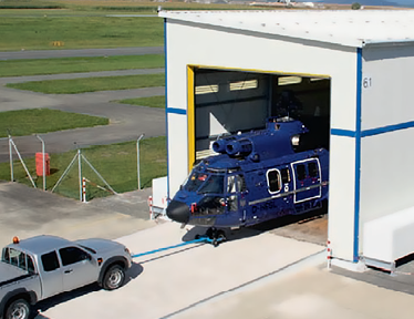 A blue truck is being loaded into a large building. AI generated content