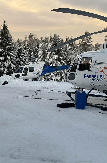 Two helicopters are parked in a snowy field. AI generated content