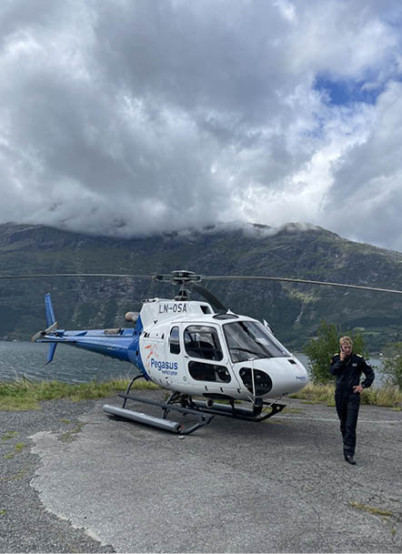A man is standing next to a helicopter on a gravel road. AI generated content