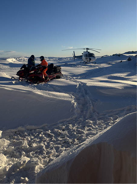 A helicopter is flying over a snowy hillside where a group of people are skiing. AI generated content