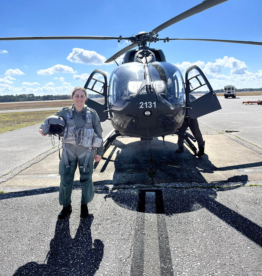 A woman stands next to a helicopter with the number 234 on it. AI generated content