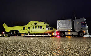 A large yellow helicopter is being towed by a truck. AI generated content