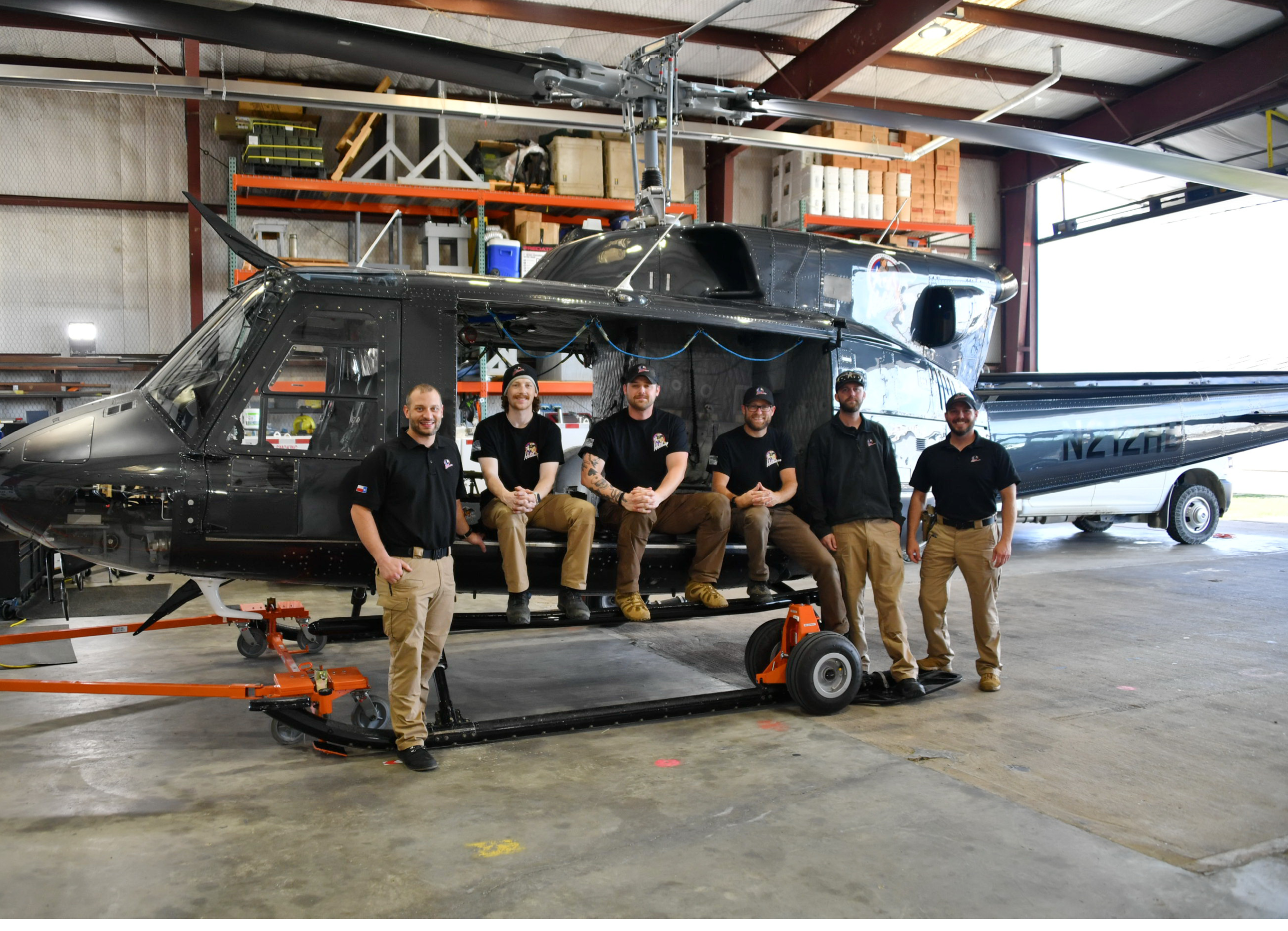 A group of men pose in front of a helicopter. AI generated content