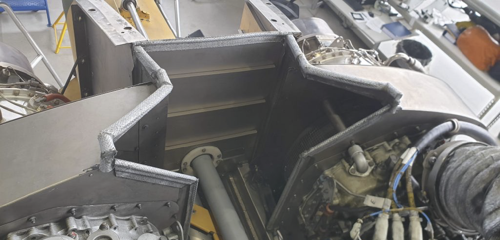 A man is sitting in a cockpit of a helicopter, wearing a helmet and a uniform. AI generated content