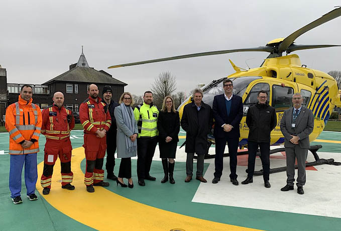 A group of people are standing in front of a yellow helicopter. AI generated content