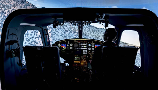 A man is sitting in a cockpit of a plane, flying it through a snowy landscape. AI generated content