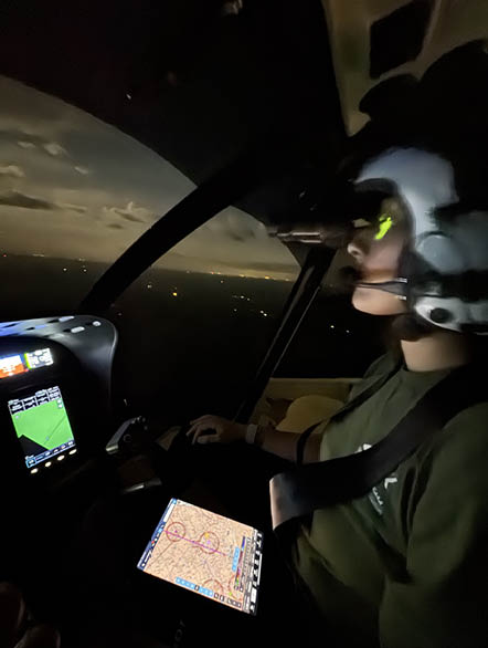 A person is sitting in a helicopter, looking at a map on a tablet. AI generated content