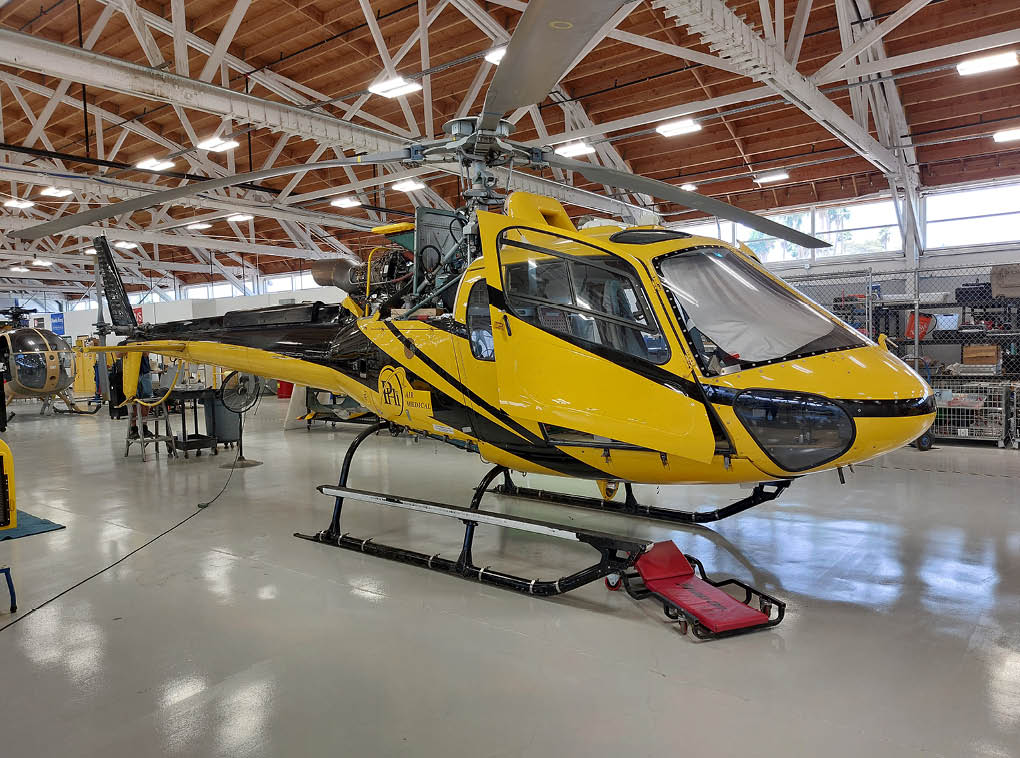 A yellow helicopter is parked in a hangar. AI generated content