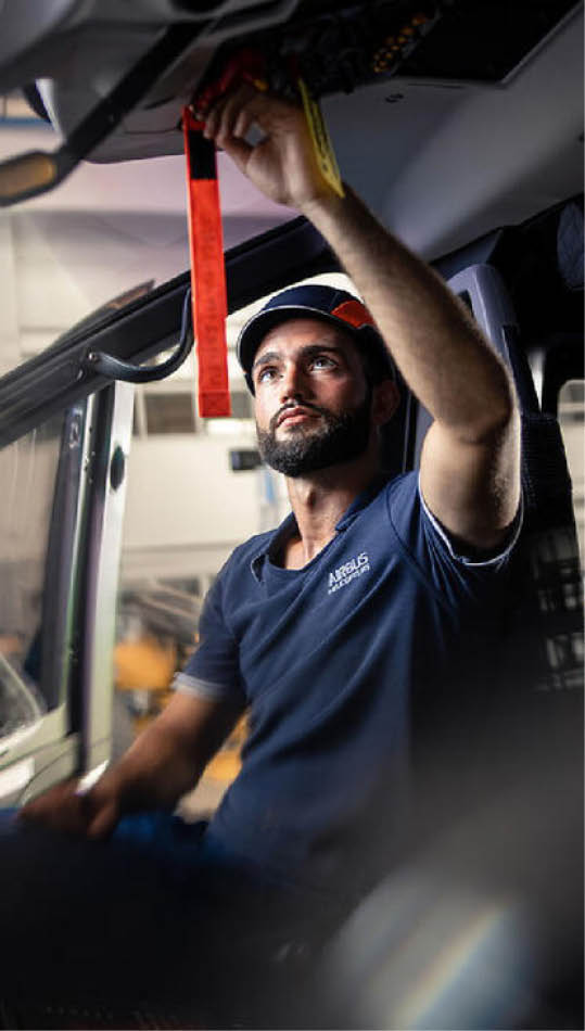 A man wearing a blue shirt is adjusting a mirror in a vehicle. AI generated content