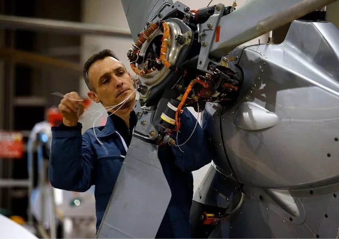 A man is working on a helicopter, fixing its wiring. AI generated content