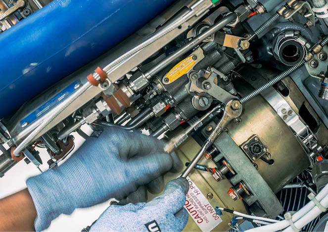 A person wearing gloves is working on a machine, possibly an engine. AI generated content