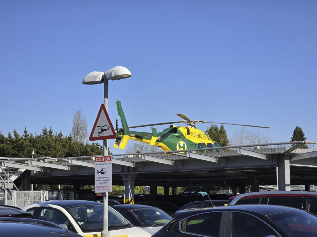 A man is sitting in a cockpit of a helicopter, wearing a helmet and a uniform. AI generated content