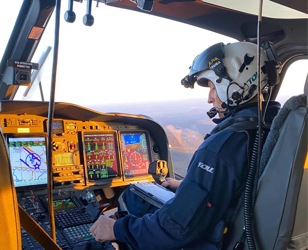 A man is sitting in a helicopter cockpit with a mountain view. AI generated content