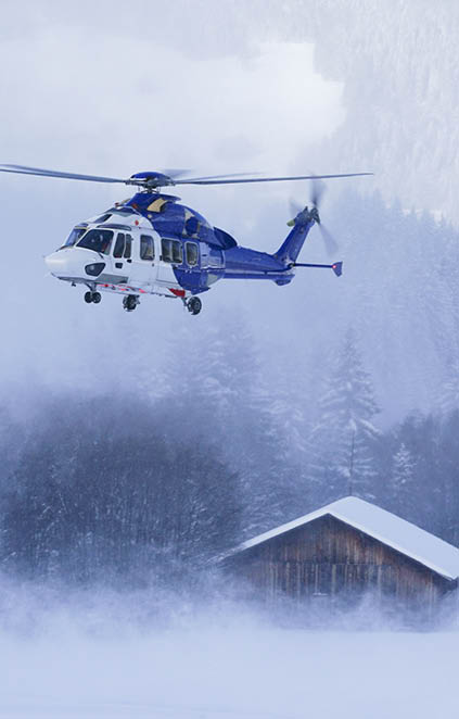 A helicopter is flying over a snowy field, with a house in the background. AI generated content
