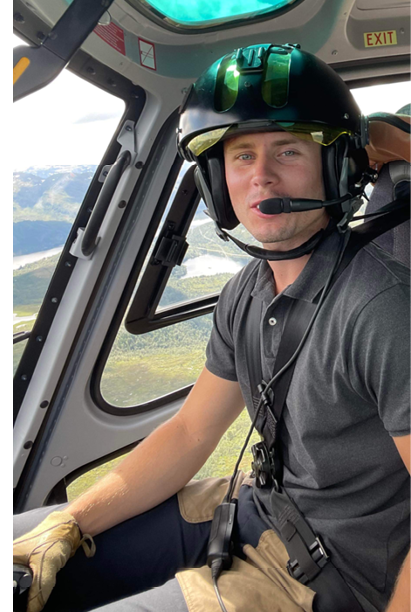 Two men are sitting in a helicopter, one wearing a helmet and the other wearing glasses. AI generated content