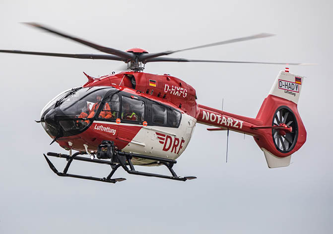 A red and white helicopter with a red cross on the side is flying in the sky. AI generated content