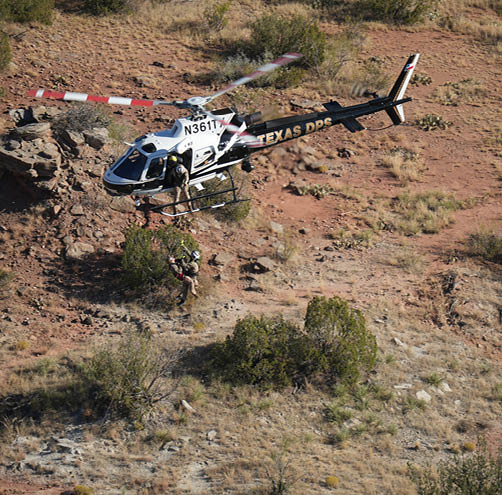 A white helicopter with red and white stripes on the tail. Description generated by AI