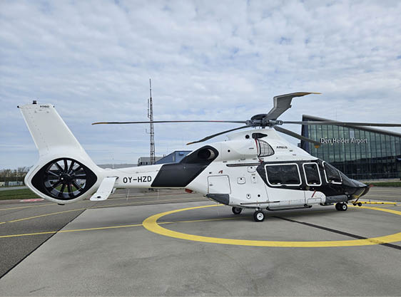 A white helicopter with a yellow circle on the ground. Description generated by AI
