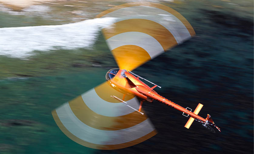 A red and yellow airplane flying over the ocean. Description generated by AI