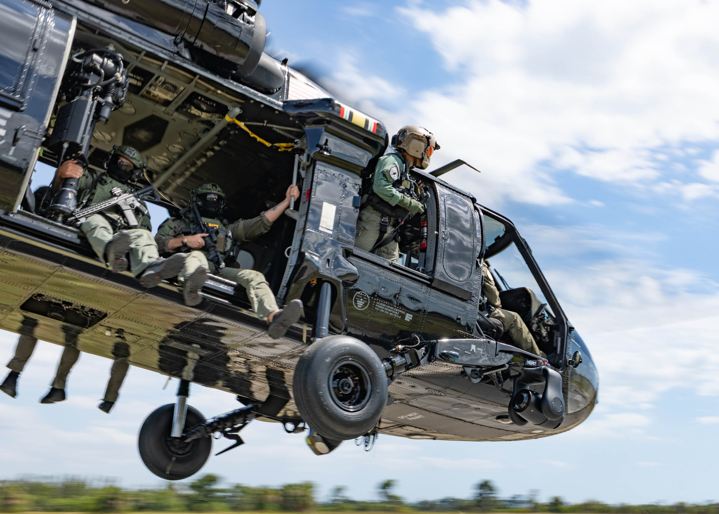 A helicopter with four people on it. Description generated by AI