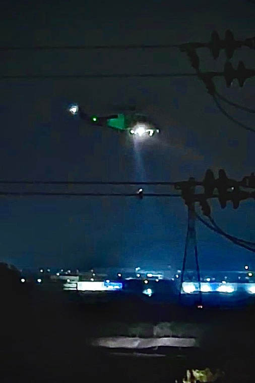 A helicopter is flying over a city at night. Description generated by AI