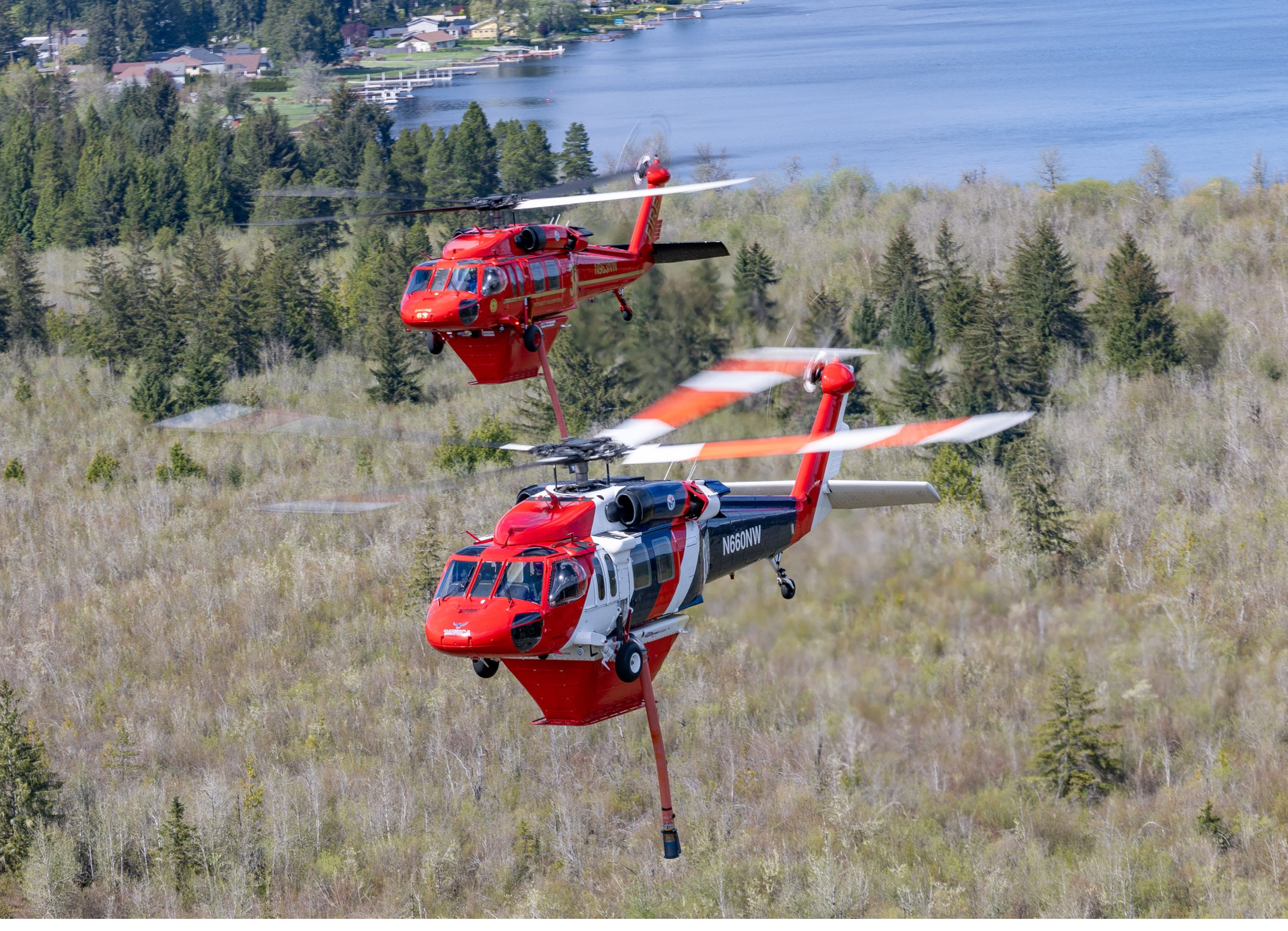 Two red and white helicopters flying in the air. Description generated by AI