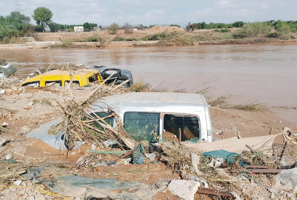 A white truck is submerged in muddy water. Description generated by AI