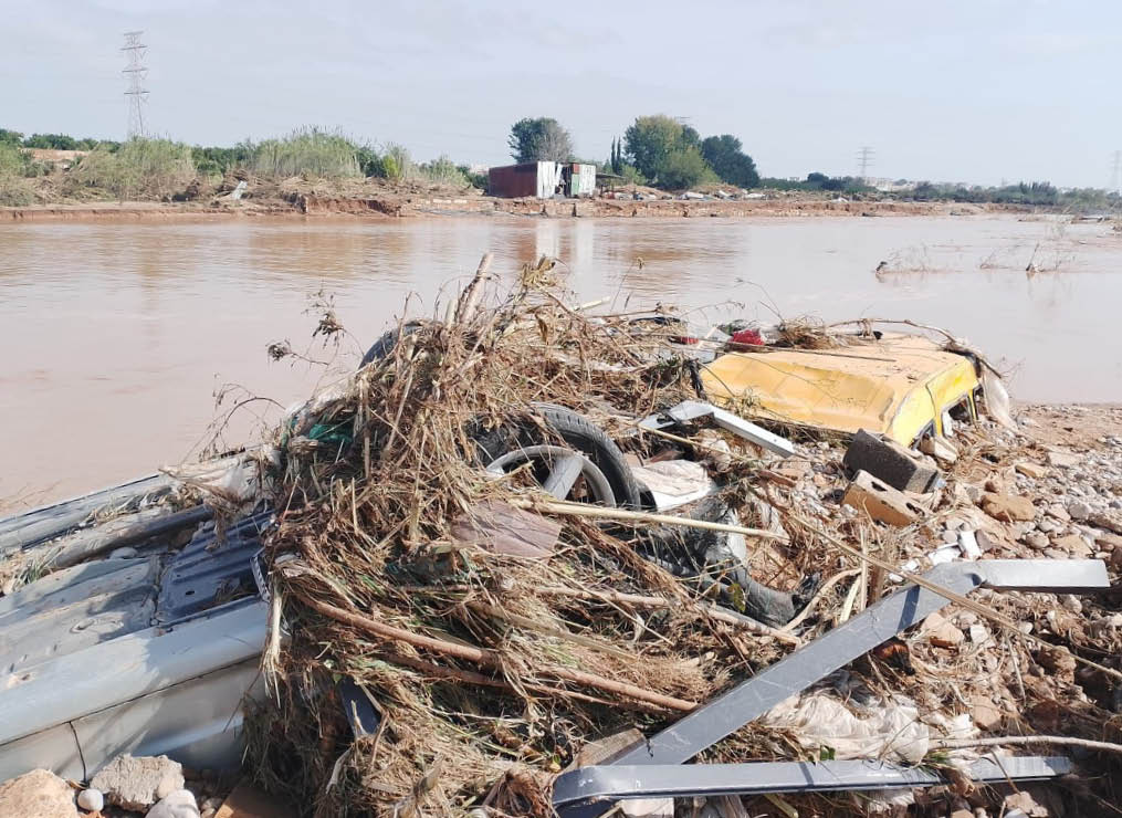 A pile of junk is on the side of a river. Description generated by AI