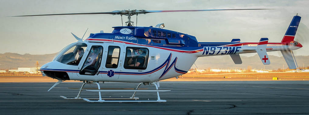 A red, white, and blue helicopter with the number 873 on the tail. Description generated by AI