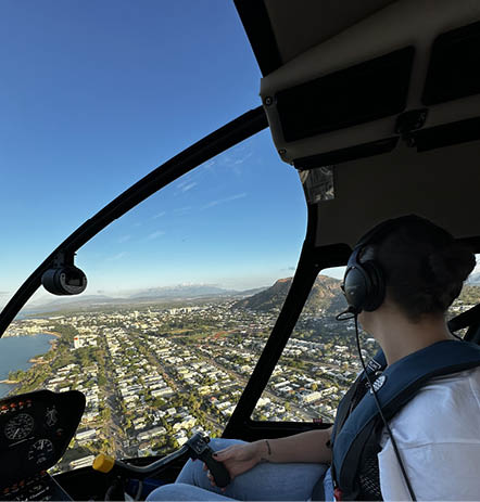 A woman in a helicopter looking out at a city. Description generated by AI