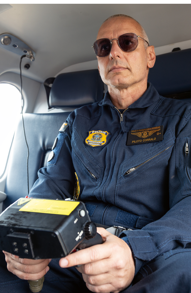 A man wearing a blue uniform is sitting in a chair. Description generated by AI