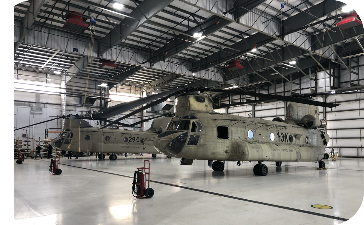 A large military helicopter is parked in a hangar. Description generated by AI