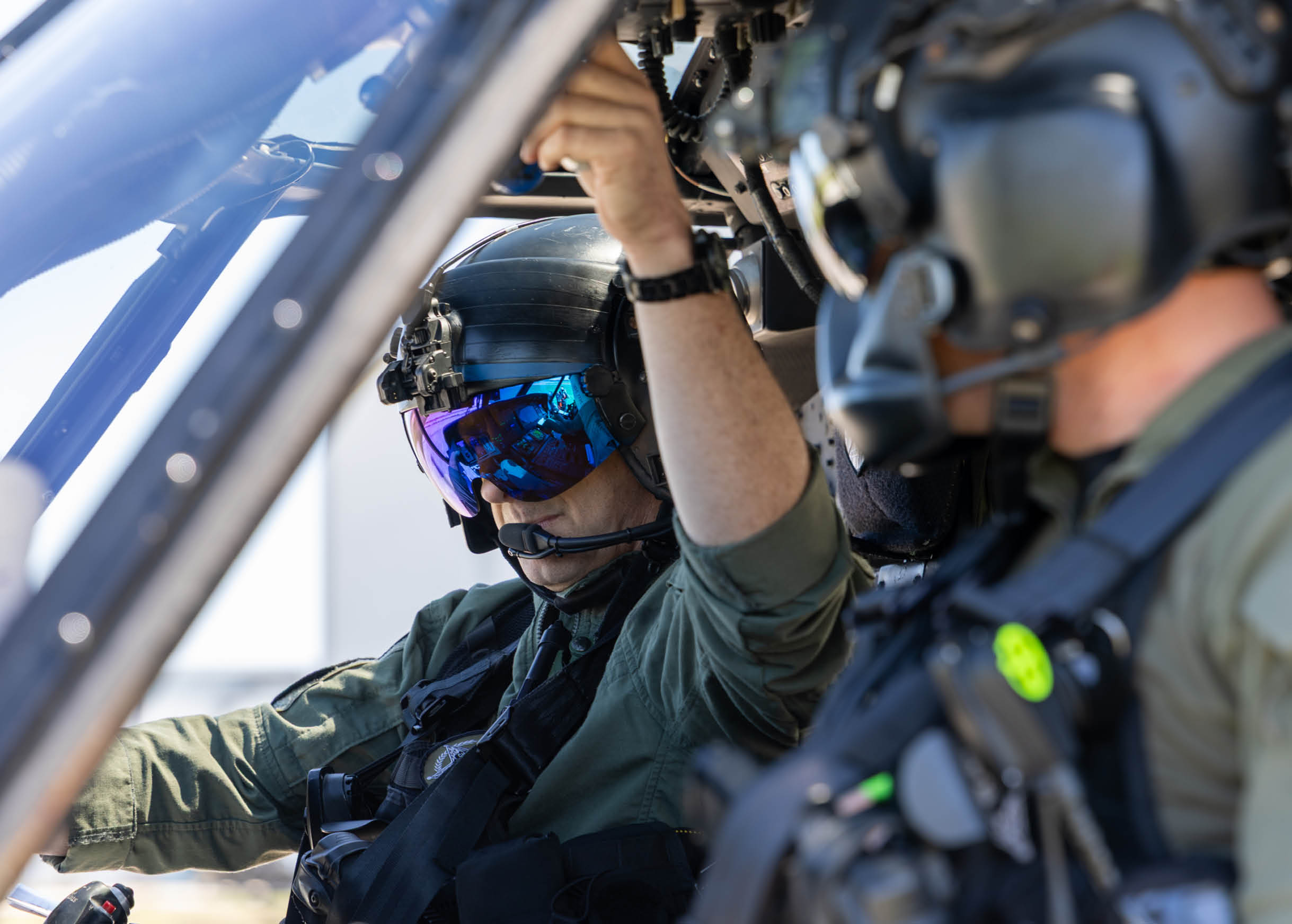 A man wearing a green shirt and black helmet. Description generated by AI