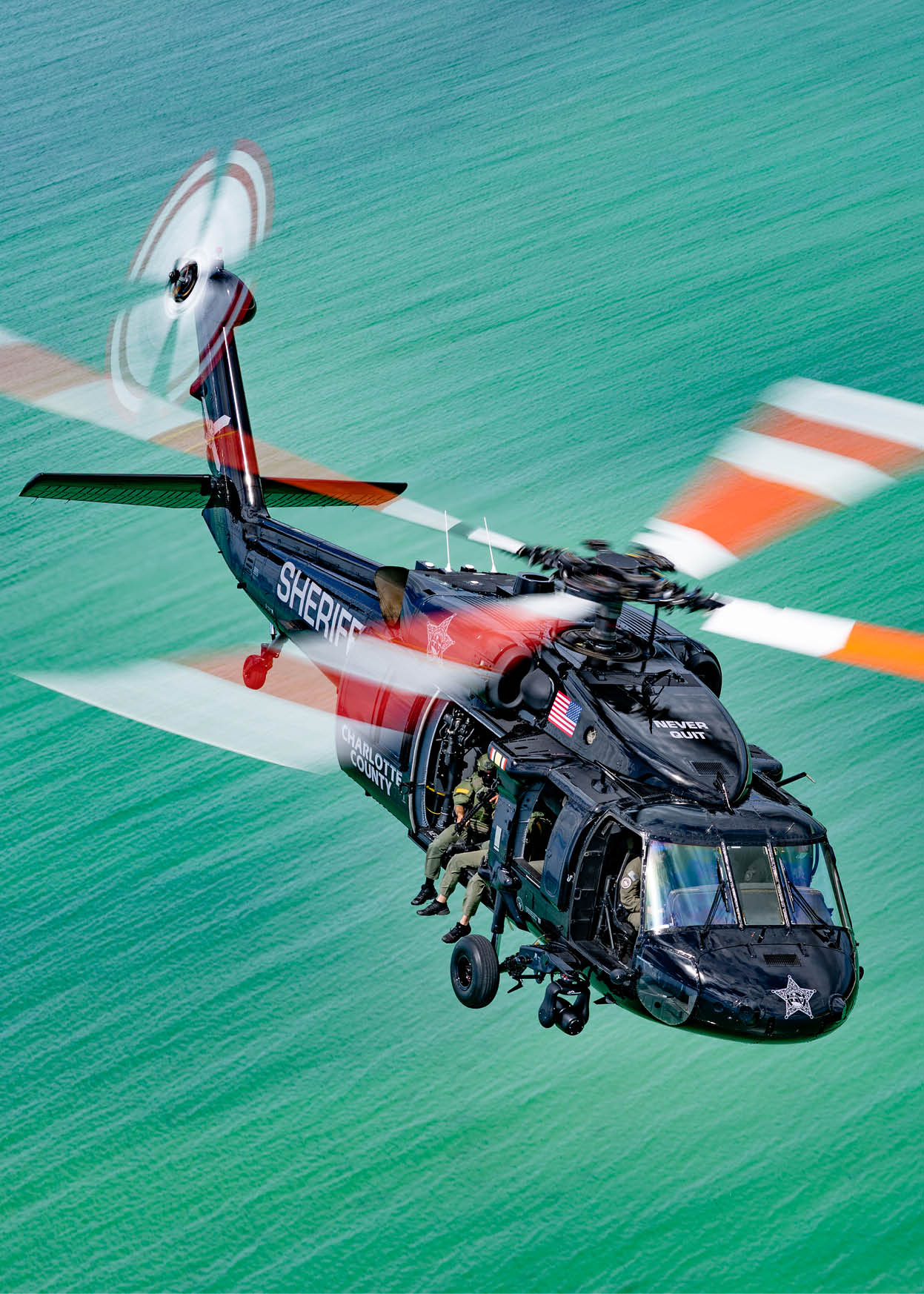 A helicopter flying in the air. Description generated by AI
