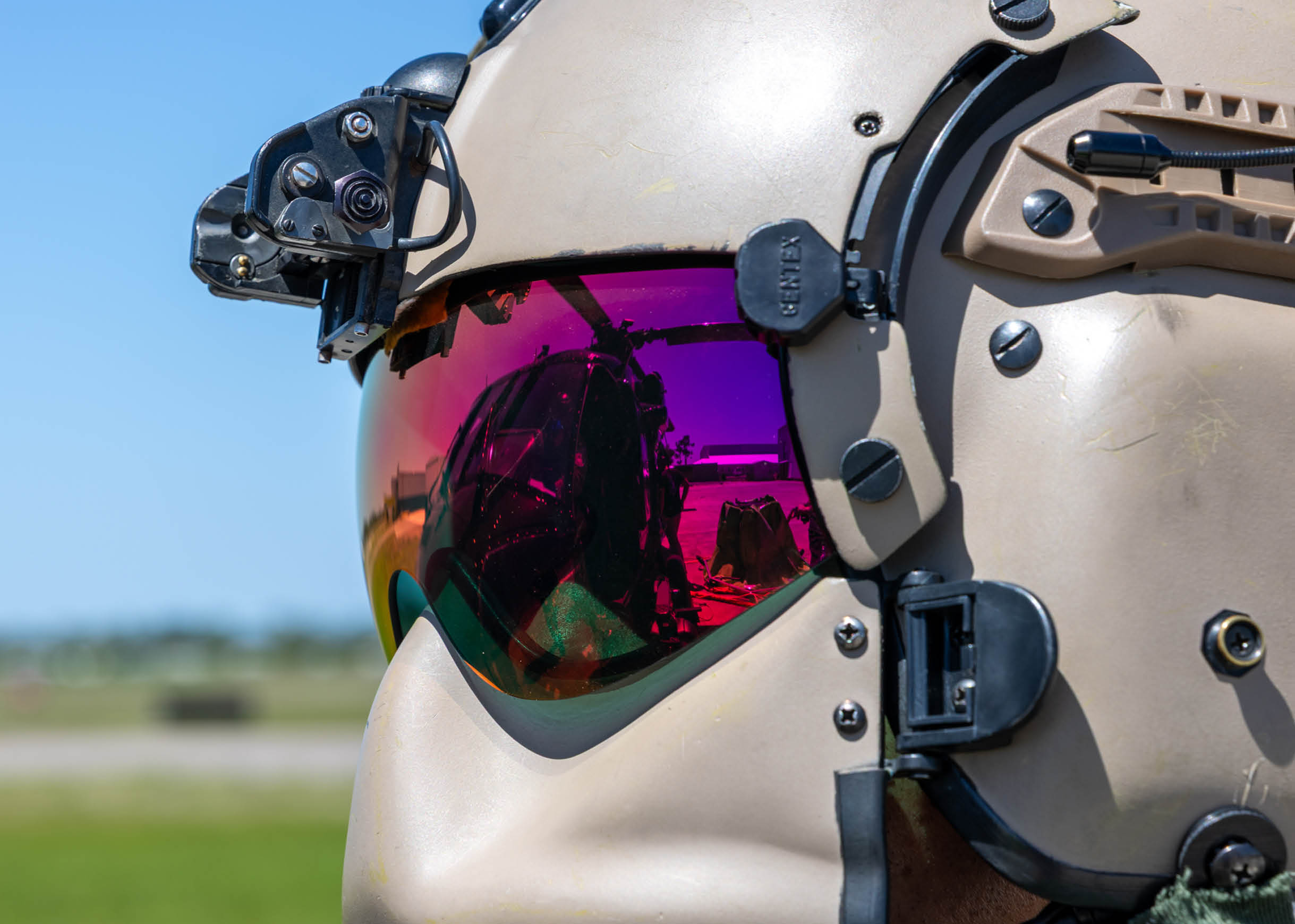 A tan helmet with a visor and a pair of sunglasses. Description generated by AI