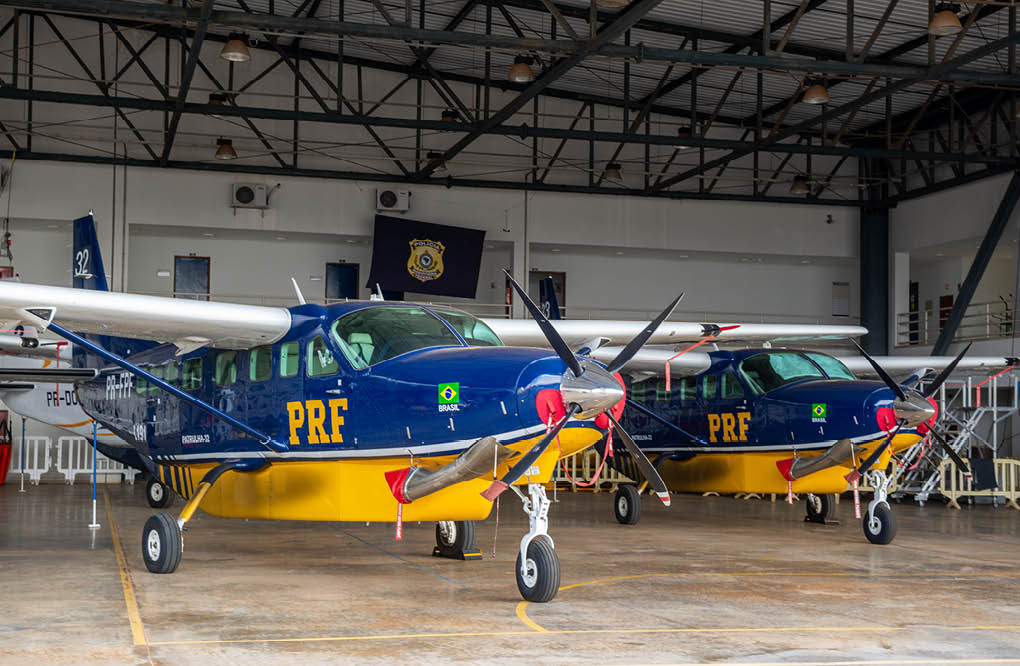 Two small airplanes are parked in a hangar. Description generated by AI