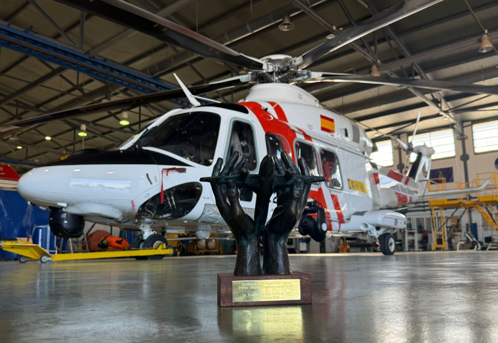 A trophy is on display in front of a helicopter. Description generated by AI