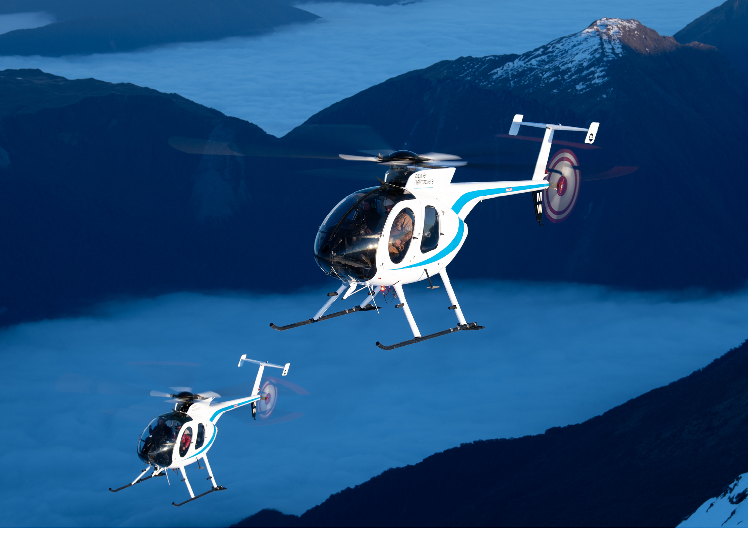 Two helicopters flying in the sky. Description generated by AI