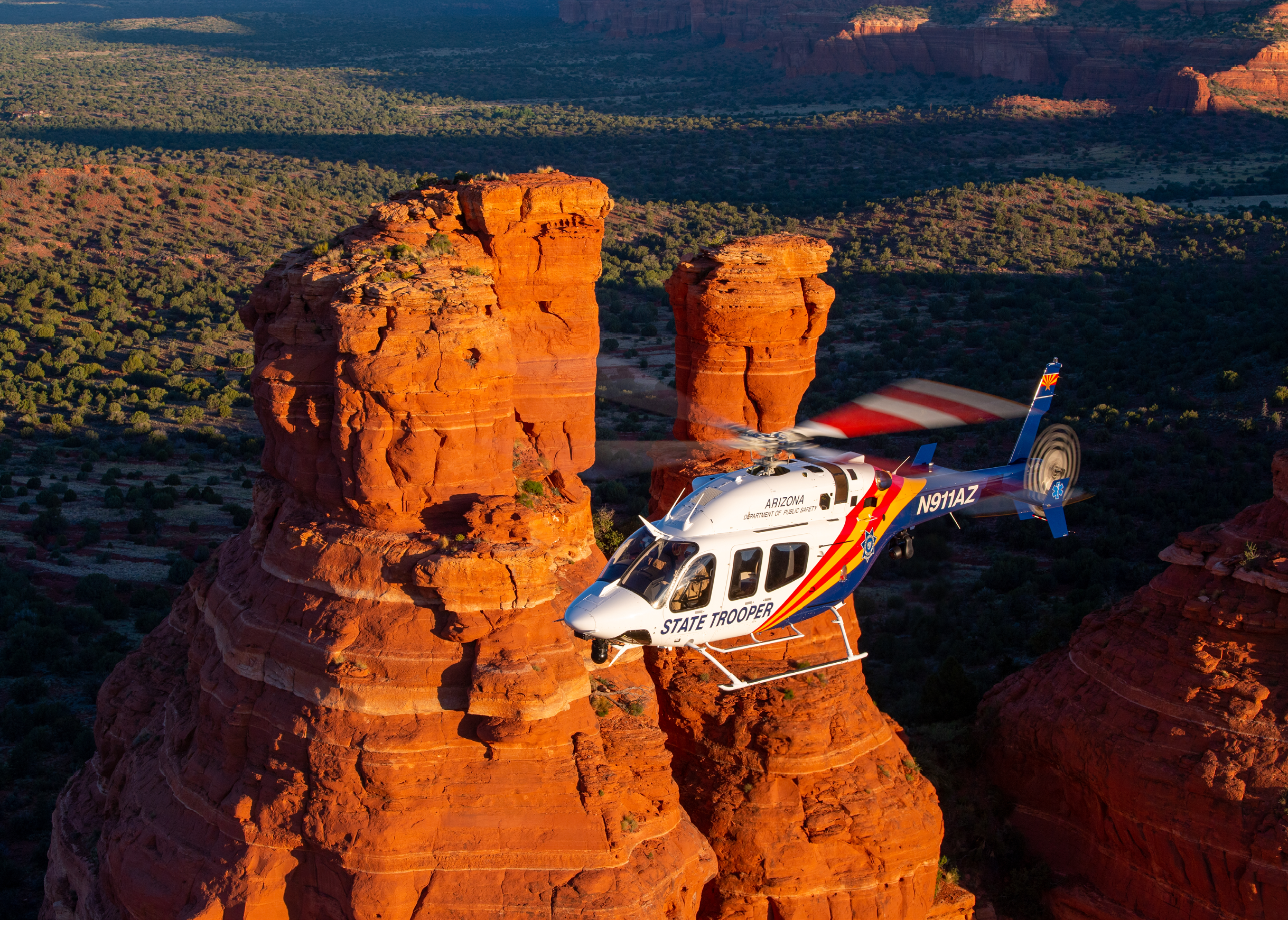 A helicopter is flying over a rock formation. Description generated by AI