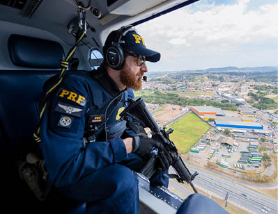 A man wearing a blue shirt and a helmet is sitting in a helicopter. Description generated by AI