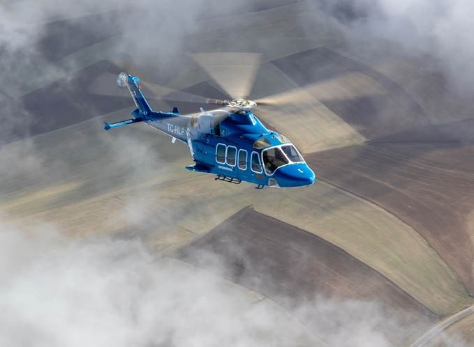 A blue helicopter flying in the air. Description generated by AI