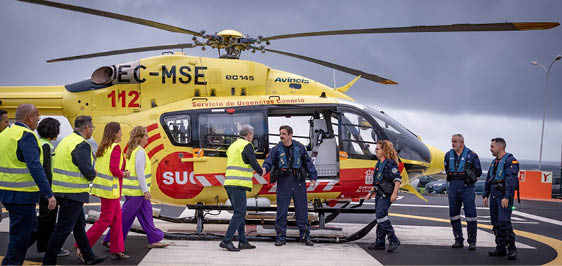 A yellow and red helicopter with the number 12 on it. Description generated by AI