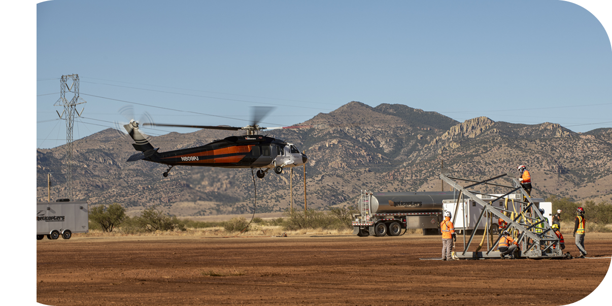 A helicopter is flying over a field. Description generated by AI