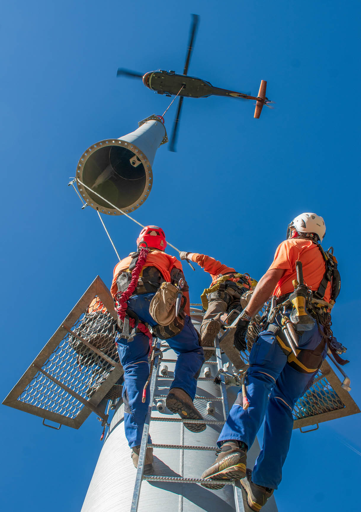 Two men are working on a tower. Description generated by AI